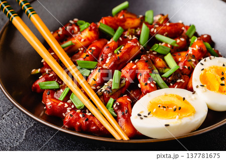 Tteokbokki, Teopokki fried rice cake in black bowl. Tteokbokki, Teopokki fried rice cake in black bowl. 137781675