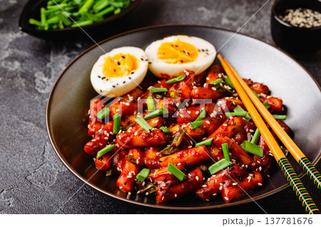 Tteokbokki, Teopokki fried rice cake in black bowl. Tteokbokki, Teopokki fried rice cake in black bowl. 137781676
