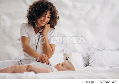 Check up routine. Using stethoscope. Female doctor is with newborn baby indoors 137782187