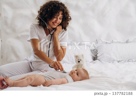 Check up routine. Using stethoscope. Female doctor is with newborn baby indoors 137782188