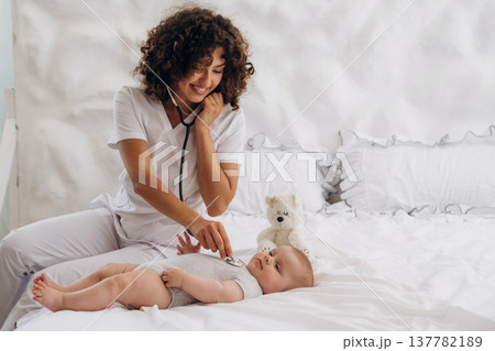 Check up routine. Using stethoscope. Female doctor is with newborn baby indoors 137782189