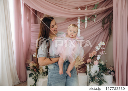 In cute dress. Happy mother is with her baby daughter indoors 137782280