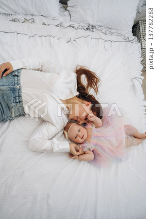 Happy mother is with her baby daughter indoors Happy mother is with her baby daughter indoors 137782288
