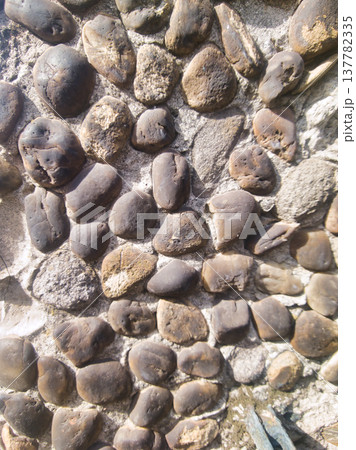Detailed Texture Photography of an Old Stone Wall Built with Rounded River Rocks and Concrete, Capturing Natural Architectural Patterns and Ancient Masonry Surface in Budapest City Garden, Hungary. Detailed Texture Photography of an Old Stone Wall Built with Rounded River Rocks and Concrete, Capturing Natural Architectural Patterns and Ancient Masonry Surface in Budapest City Garden, Hungary. 137782335