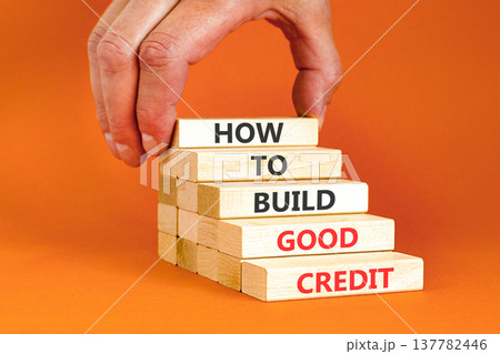 How to build good credit symbol. Concept words How to build good credit on beautiful wooden blocks. Beautiful orange background. Businessman hand. Business how to build good credit concept. Copy space How to build good credit symbol. Concept words How to build good credit on beautiful wooden blocks. Beautiful orange background. Businessman hand. Business how to build good credit concept. Copy space 137782446