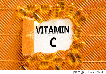 Vitamin C symbol. Concept words Vitamin C on beautiful white paper. Yellow pills tablets. Beautiful brown background. Medical healthy lifestyle Vitamin C concept. Vitamin C symbol. Concept words Vitamin C on beautiful white paper. Yellow pills tablets. Beautiful brown background. Medical healthy lifestyle Vitamin C concept. 137782661