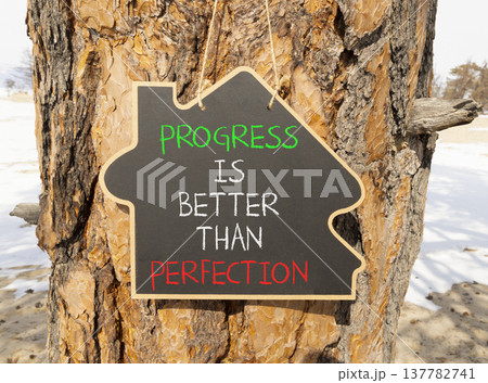Progress or perfection words symbol. Concept words Progress is better than perfection on beautiful blackboard. Beautiful old pine tree background. Business progress or perfection concept. Copy space. Progress or perfection words symbol. Concept words Progress is better than perfection on beautiful blackboard. Beautiful old pine tree background. Business progress or perfection concept. Copy space. 137782741