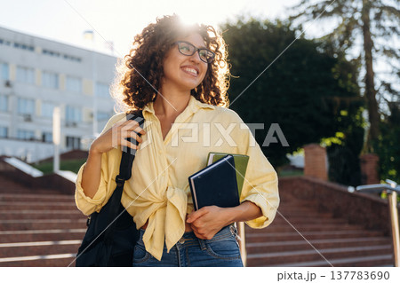 With backpack. Beautiful woman student is near the university outdoors 137783690