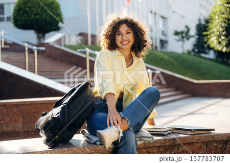 Notepads on the side, conception of education. Beautiful woman student is near the university outdoors Notepads on the side, conception of education. Beautiful woman student is near the university outdoors 137783707