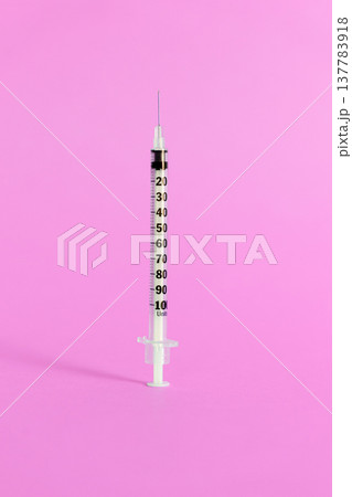 Medical syringe with needle isolated on a vibrant pink background for cosmetic beauty procedures. Close-up studio shot of a sterile disposable syringe used for facial injections, filler treatments 137783918