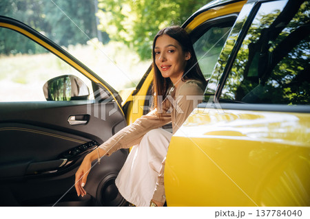 Relaxed, sitting, door is opened. Woman is with her car in the forest Relaxed, sitting, door is opened. Woman is with her car in the forest 137784040