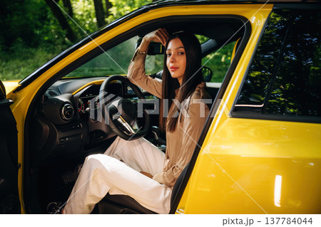 Relaxed, sitting, door is opened. Woman is with her car in the forest Relaxed, sitting, door is opened. Woman is with her car in the forest 137784044