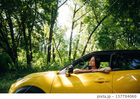 Woman is with her car in the forest Woman is with her car in the forest 137784060