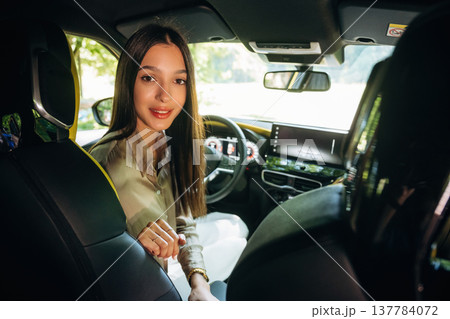 Interior of modern car. Young woman is sitting in it Interior of modern car. Young woman is sitting in it 137784072