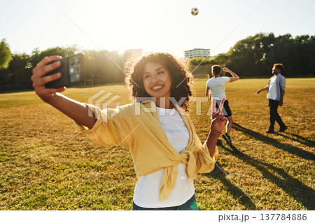 Smartphone in hand, doing selfie. Young friends are having fun on the field Smartphone in hand, doing selfie. Young friends are having fun on the field 137784886