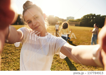 Looking at the camera, doing selfie. Young friends are having fun on the field 137784913