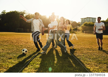 Running together. Group of friends are playing soccer on the field Running together. Group of friends are playing soccer on the field 137784916