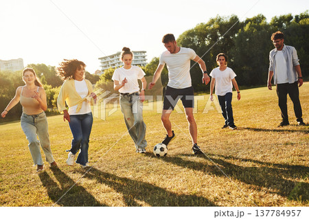 Hobby of sport. Group of friends are playing soccer on the field Hobby of sport. Group of friends are playing soccer on the field 137784957