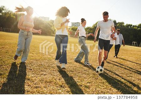 Hobby of sport. Group of friends are playing soccer on the field Hobby of sport. Group of friends are playing soccer on the field 137784958