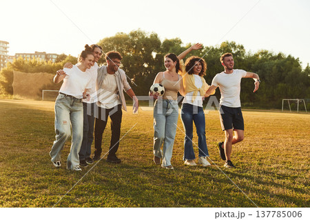 Getting ready for playing football. Young friends are having fun on the field with soccer ball Getting ready for playing football. Young friends are having fun on the field with soccer ball 137785006