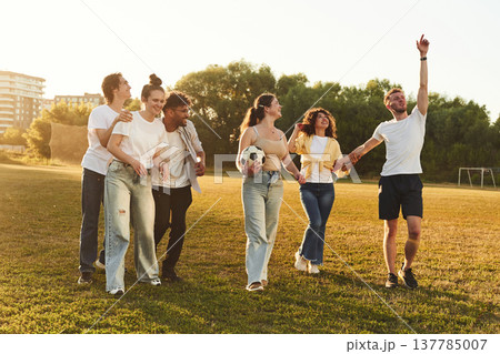 Getting ready for playing football. Young friends are having fun on the field with soccer ball Getting ready for playing football. Young friends are having fun on the field with soccer ball 137785007