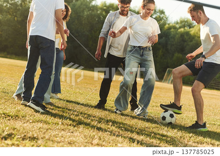 Summertime fun. Group of friends are playing soccer on the field Summertime fun. Group of friends are playing soccer on the field 137785025