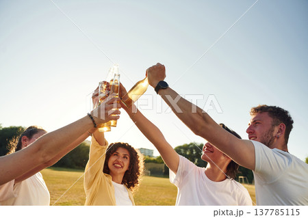 Party time, celebration. People are celebrating by cheering with beer bottles Party time, celebration. People are celebrating by cheering with beer bottles 137785115