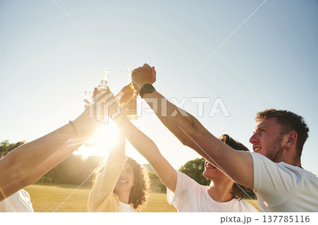 Party time, celebration. People are celebrating by cheering with beer bottles 137785116