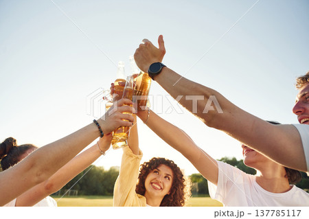 Party time, celebration. People are celebrating by cheering with beer bottles Party time, celebration. People are celebrating by cheering with beer bottles 137785117