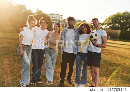 Break time, standing and posing. Young friends are having fun on the field with soccer ball Break time, standing and posing. Young friends are having fun on the field with soccer ball 137785141