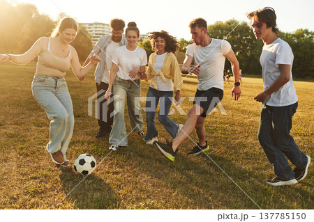 Competition and fun conception. Group of friends are playing soccer on the field Competition and fun conception. Group of friends are playing soccer on the field 137785150