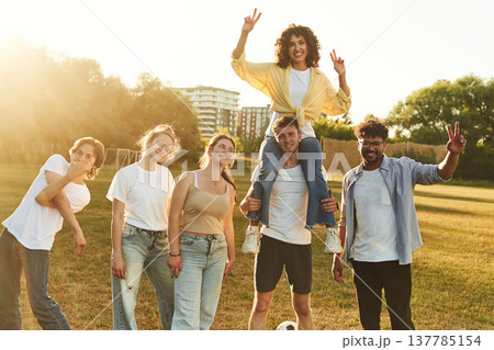 Positive facial expressions. Young friends are having fun on the field with soccer ball 137785154
