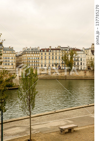 Parisian cityscape featuring historic buildings lining the Seine River embankment on an overcast sky day in Paris, France 137785270