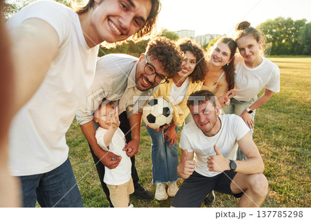 Selfie time, smiling. Young friends are having fun on the field with soccer ball 137785298