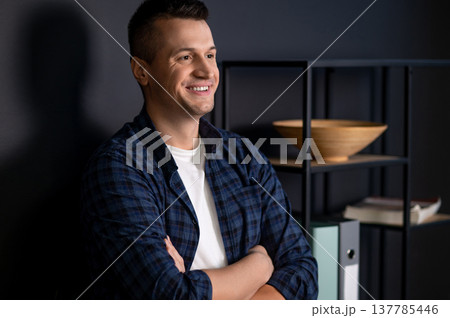 Confident man with crossed arms looking away standing in modern office interior Confident man with crossed arms looking away standing in modern office interior 137785446