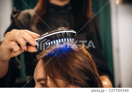 Woman is in a beauty salon with hair stylist Woman is in a beauty salon with hair stylist 137785540