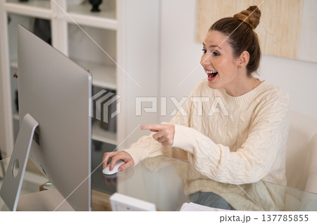 Woman in white warm sweater at home working at the table 137785855