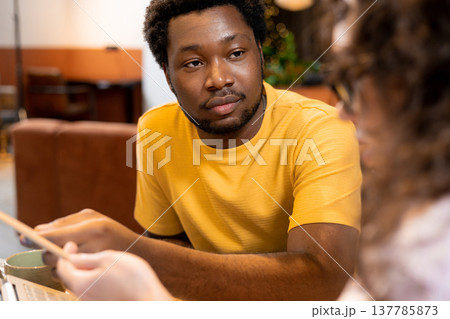 Man and woman colleagues discussing project using computer in coworking space Man and woman colleagues discussing project using computer in coworking space 137785873