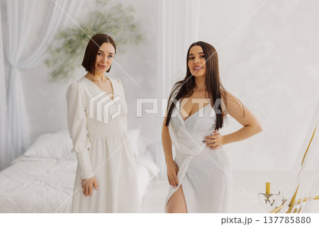 Two beautiful women in long dresses in the studio Two beautiful women in long dresses in the studio 137785880