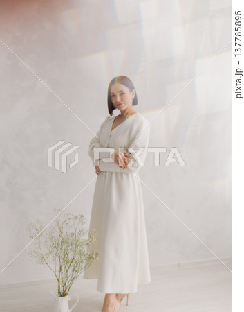 Young beautiful woman posing near white wall Young beautiful woman posing near white wall 137785896