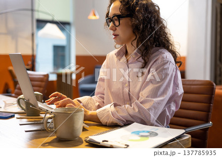 Caucasian woman working on laptop typing in coworking space Caucasian woman working on laptop typing in coworking space 137785935