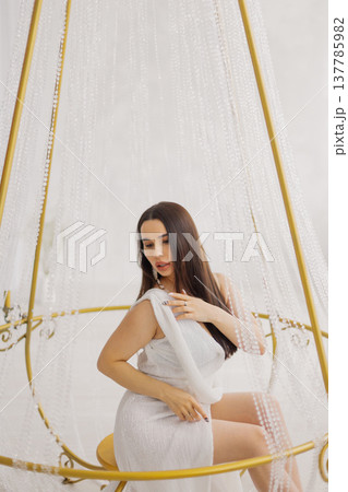 Young beautiful woman posing near gilded crystal Young beautiful woman posing near gilded crystal 137785982