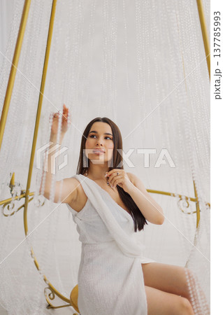 Young beautiful woman posing near gilded crystal Young beautiful woman posing near gilded crystal 137785993