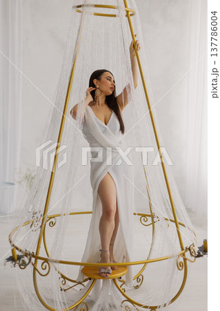 Young beautiful woman posing near gilded crystal Young beautiful woman posing near gilded crystal 137786004