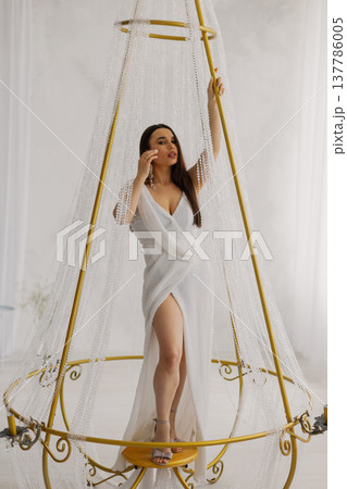Young beautiful woman posing near gilded crystal Young beautiful woman posing near gilded crystal 137786005