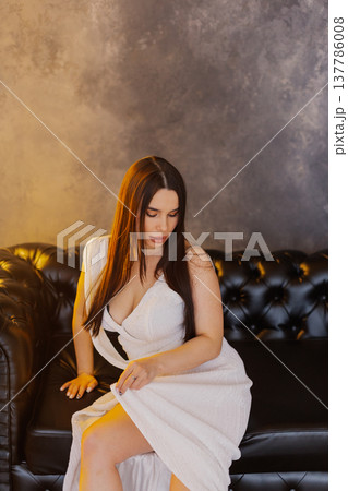 Young beautiful woman posing on leather sofa 137786008
