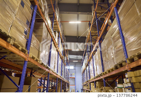 High racking systems in warehouse aisle loaded with pallets and boxed inventory High racking systems in warehouse aisle loaded with pallets and boxed inventory 137786244