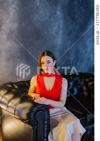 Young beautiful woman posing on leather sofa 137786260