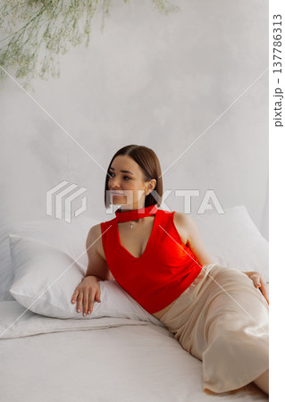 Young beautiful woman posing on a luxurious bed Young beautiful woman posing on a luxurious bed 137786313