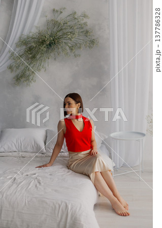Young beautiful woman posing on a luxurious bed Young beautiful woman posing on a luxurious bed 137786328